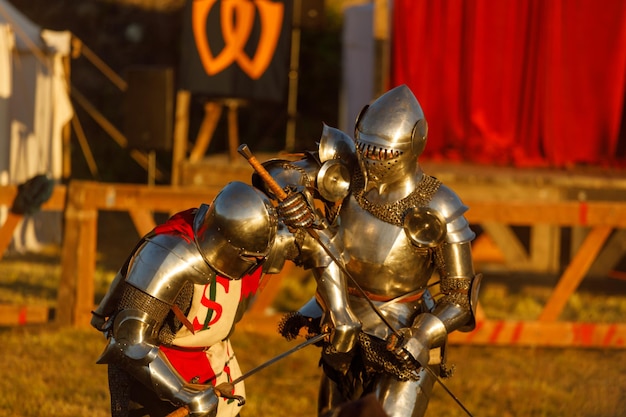 Knights in medieval armor fight at the tournament in the summer. High quality photo