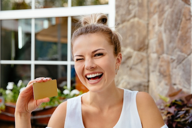 Knipogende vrouw met creditcard