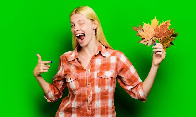 Knipogende vrouw met gele bladeren herfst verkoop herfst vogue trend lachend meisje in geruit hemd