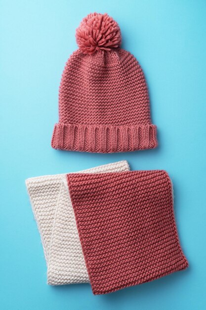 Knit winter hat and scarf over blue background