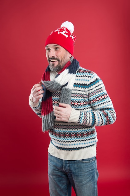 Knitted accessories. Winter weather style. Winter male fashion collection. Mature man enjoy warmth and comfort. Christmas holiday time. Happy bearded man red background. Cold winter conditions.