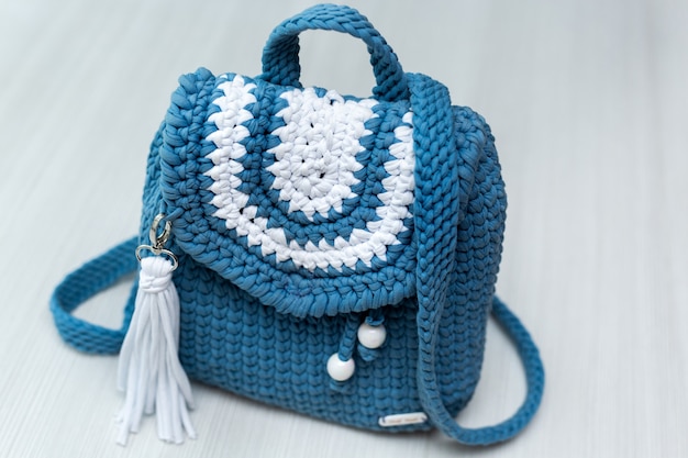 Knitted blue backpack on white background