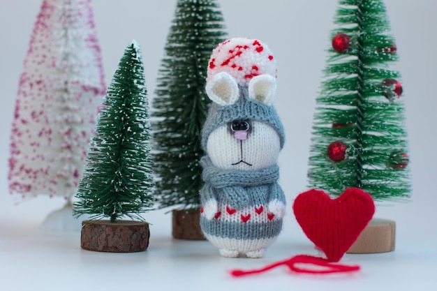 Knitted bunny with gifts on a wooden background with a Christmas tree New Year of the hare 2023 handmade