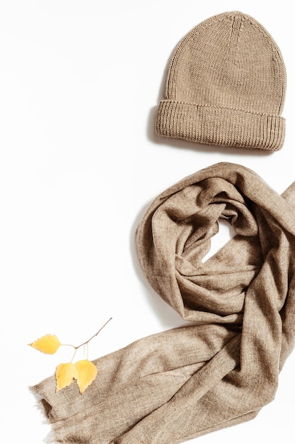 Knitted hat wollen scarf with yellow leaves Autumn Fashion clothing concept warm wear