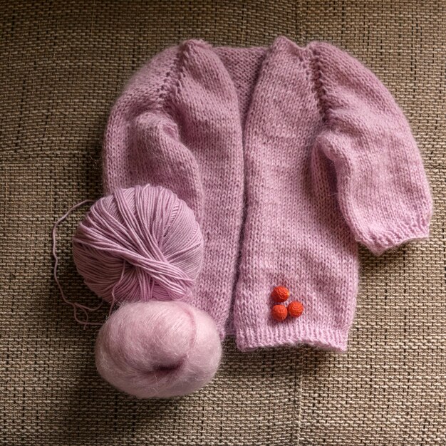 Photo knitted jacket for a girl pink color knitting texture handicraft concept hand knitting
