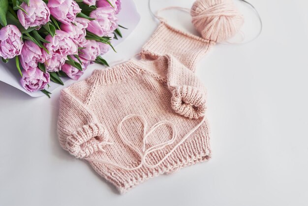 Knitted kids clothes and accessories for knitting Needlework and knitting Hobbies and creativity Knit for children Handmade Pink sweater and tulips