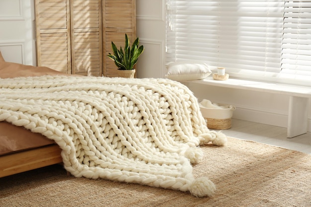 Knitted merino wool plaid on bed indoors Interior design