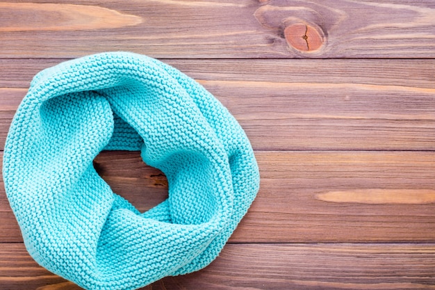 Knitted mint snud on a wooden table.