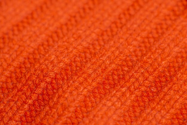 Knitted orange sweater close up background