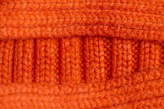 Knitted orange sweater close up background