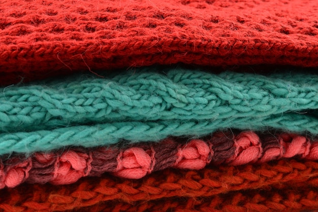 Knitted red, orange, green scarves. Collection of woolen clothes.