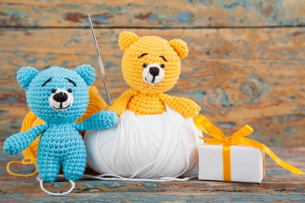 Knitted small bears on an old wooden . Handmade, knitted toy. Amigurumi