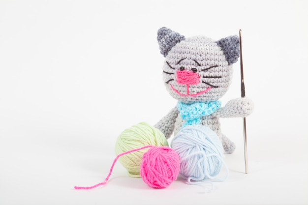 Вязаный маленький кот на белом фоне. Ручная вязаная игрушка. Amigurumi