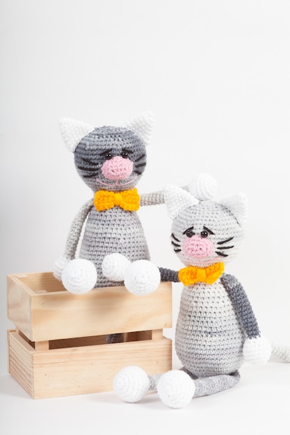 Knitted small cat on an white . Handmade, knitted toy. Amigurumi