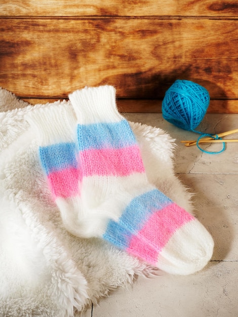 Knitted socks on a white fur background