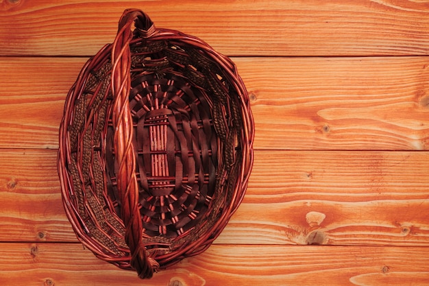 Knitted straw basket on wooden table