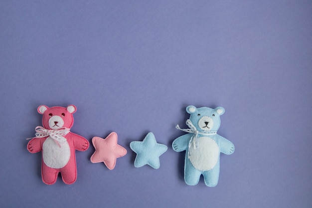 Photo knitted toys cloud, star, bear, ram, owl, bird pink and blue colors lie on a purple background