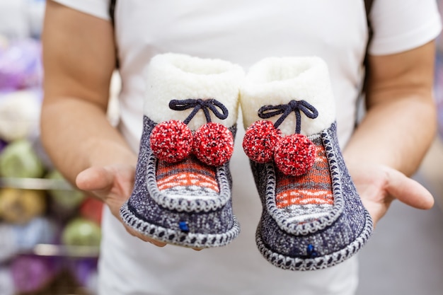 Knitted warm home Slippers in the hands of a man close up