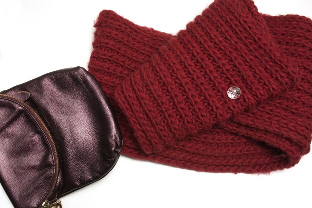 Knitted winter scarf and leather purse isolated on white background