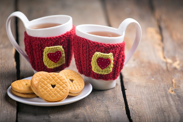 Knitted woolen cups on a wooden table