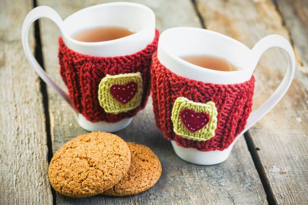 Knitted woolen cups on a wooden table