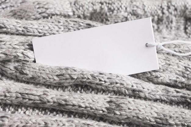 Photo knitted woolen fabric with blank card for text or label. autumn or winter season