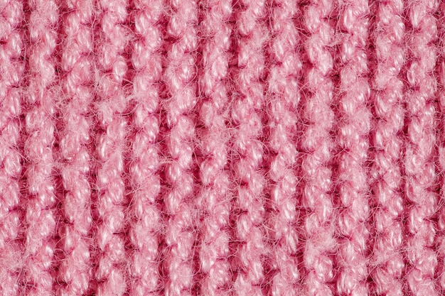 Knitted yarn made of pink wool threads, background structure, close-up macro view