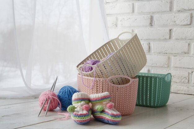 Knitten things and needlework accessories in home organizers colored baskets