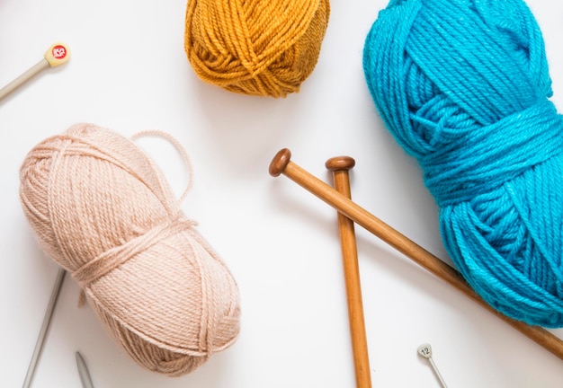 Knitting background Balls of wool and knitting needles on a plain background