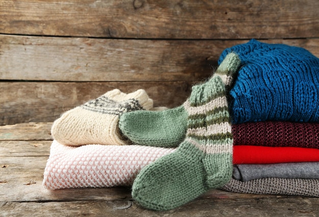 Knitting clothes on wooden background