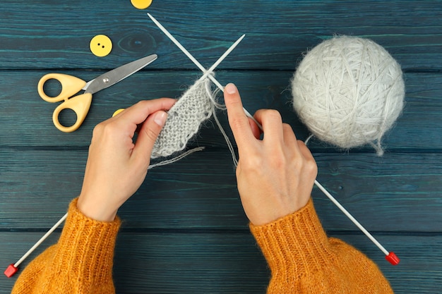 Knitting concept with yarn ball on wooden background.