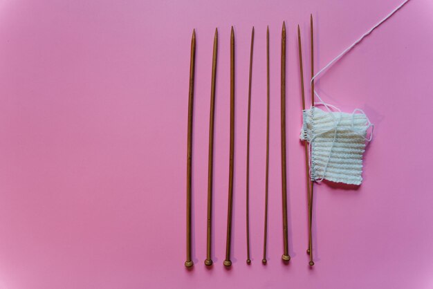 knitting needles on pink background