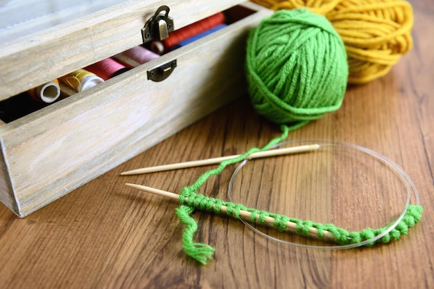 knitting needles with ball of wools on table