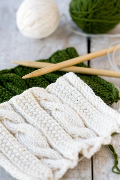 Knitting pattern and needles on a wooden background