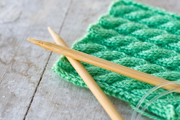 Knitting pattern and needles on a wooden background