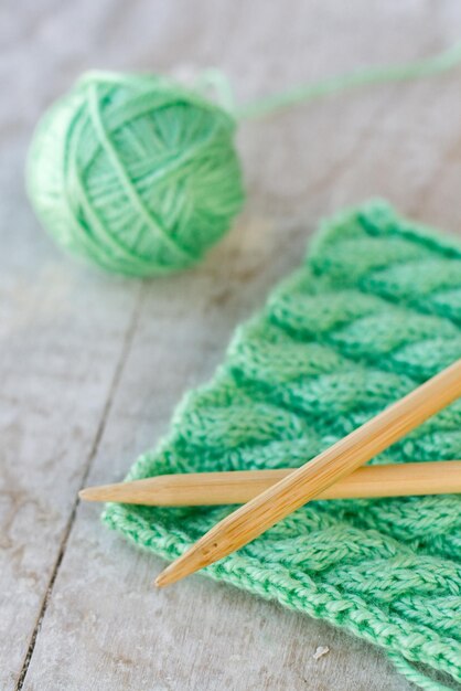 Knitting pattern and needles on a wooden background