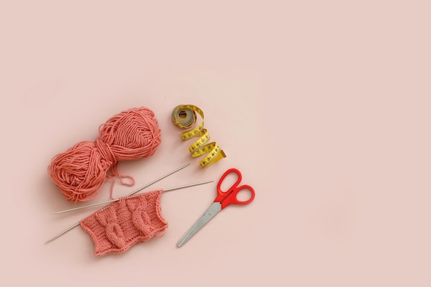 knitting and a skein of thread scissors and a measuring tape with copy space