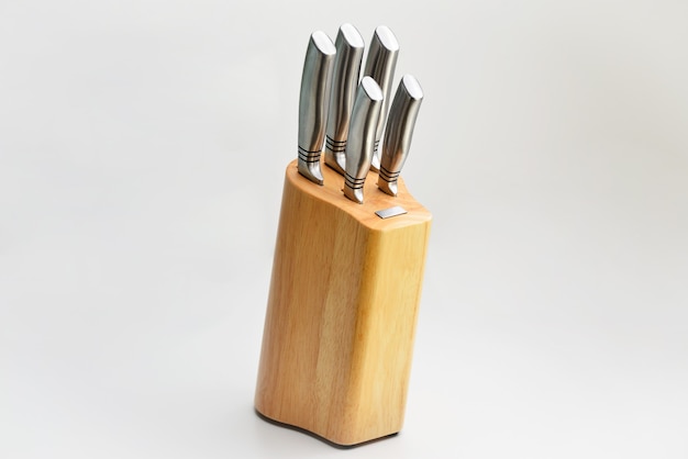 Knives in wooden block on white background