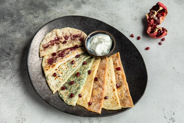 Фото knoblauch naan и черная тарелка индийский хлеб наан с чесночным маслом на деревянном столе