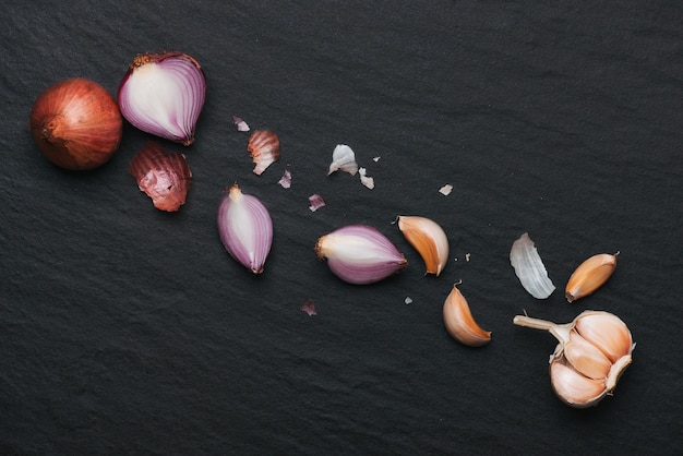 Knoflook en ui op de zwarte stenen tafel