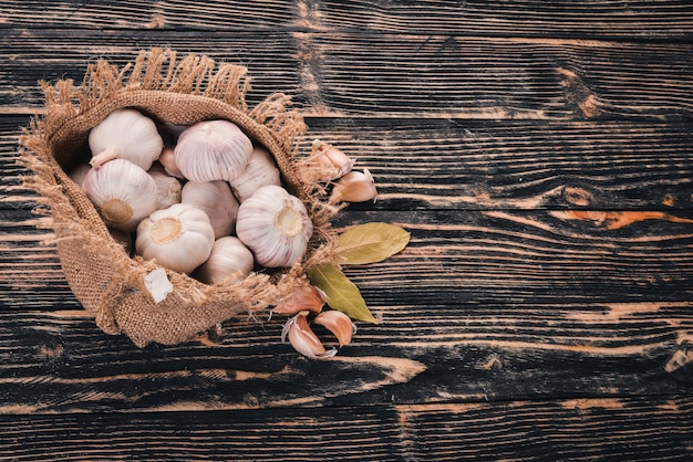 Knoflook in een zak oude doek Verse knoflook op een houten achtergrond Bovenaanzicht Vrije ruimte voor tekst