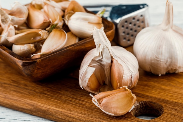 Knoflook op een rustieke tafel in een houten kom Verse gepelde knoflook