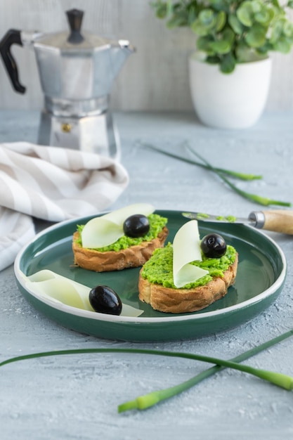 Knoflookbrood Stokbrood plakjes met kruidenboter olijven kaas en knoflookpijlen in groen bord