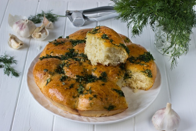 Knoflookbroodjes in bakvorm op een houten tafel