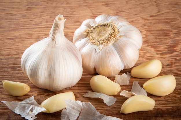 Knoflookteentjes en bol geÃ¯soleerd op houten achtergrond..