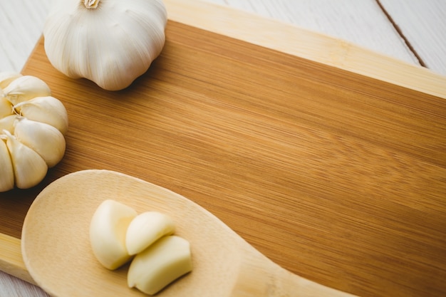 Knoflookteentjes en bol op hakbord