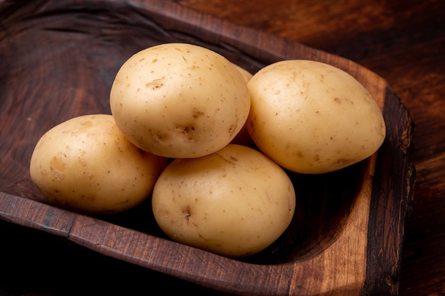 Knollen van grote jonge aardappelen op een houten ondergrond.