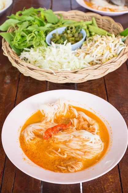 Knomjean、タイの米のパセリは、木のテーブルにカレーを添えて