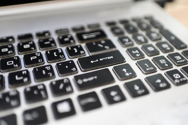 Knoppen van zwart-wit met ThaiEnglish-toetsenbord op laptop