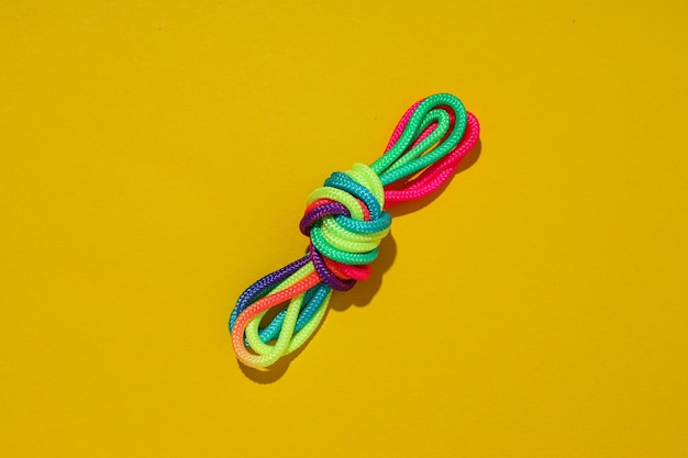 A knot of multicolored laces on a yellow background